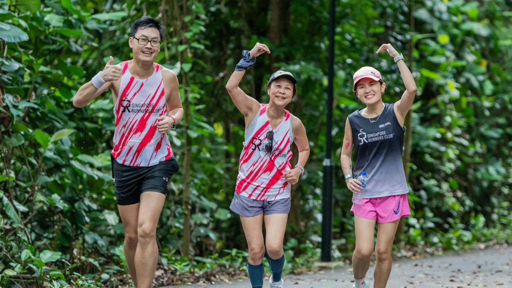 Three runners jogging in a lush green forest, showing determination and joy.